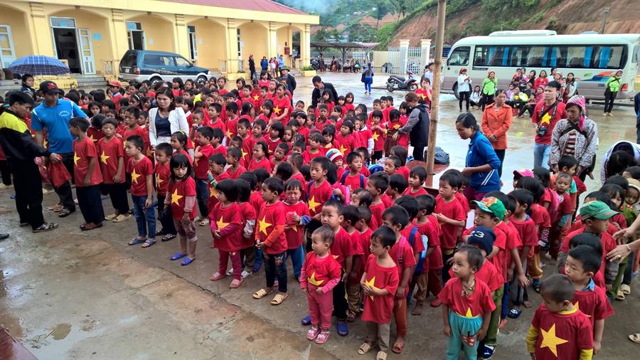 Các em học sinh khoác lên mình chiếu áo cờ đỏ sao vàng được trao tặng