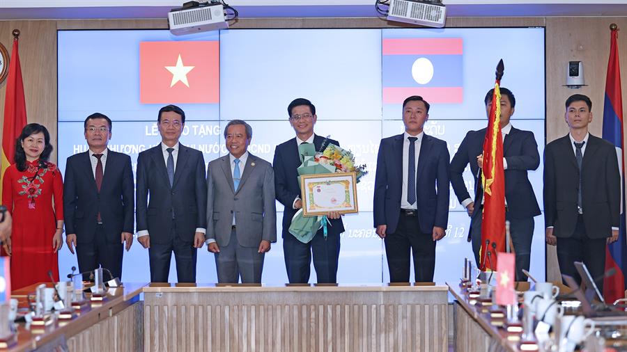 Cục trưởng Okviphoatdong88 vô tuyến điện Việt Nam Lê Văn Tuấn và các Phó Cục trưởng Nguyễn Phương Anh, Trần Mạnh Tuấn đón nhận Huân chương Hữu nghị từ Bộ trưởng Boviengkham Vongdara - Bộ Công nghệ và Truyền thông nước Cộng hòa Dân chủ Nhân dân Lào, thừa ủy quyền của Thủ tướng Chính phủ Lào trao tặng và đón nhận hoa chúc mừng từ Bộ trưởng Bộ Thông tin và Truyền thông Việt Nam - Nguyễn Mạnh Hùng