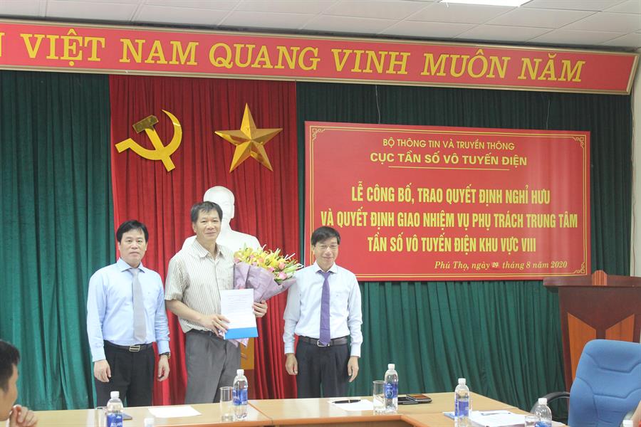 Vụ trưởng Vụ TCCB Phạm Minh Tiến và Cục trưởng Cục Tần số VTĐ Nguyễn Đức Trung trao Quyết định và tặng hoa ông Nguyễn Tiến Vũ Giang
