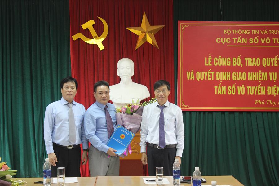 Vụ trưởng Vụ TCCB Phạm Minh Tiến và Cục trưởng Cục Tần số VTĐ Nguyễn Đức Trung trao Quyết định và tặng hoa ông Nguyễn Hải Anh